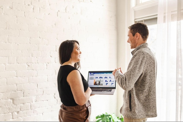 Two change management colleagues with a laptop having a conversation
